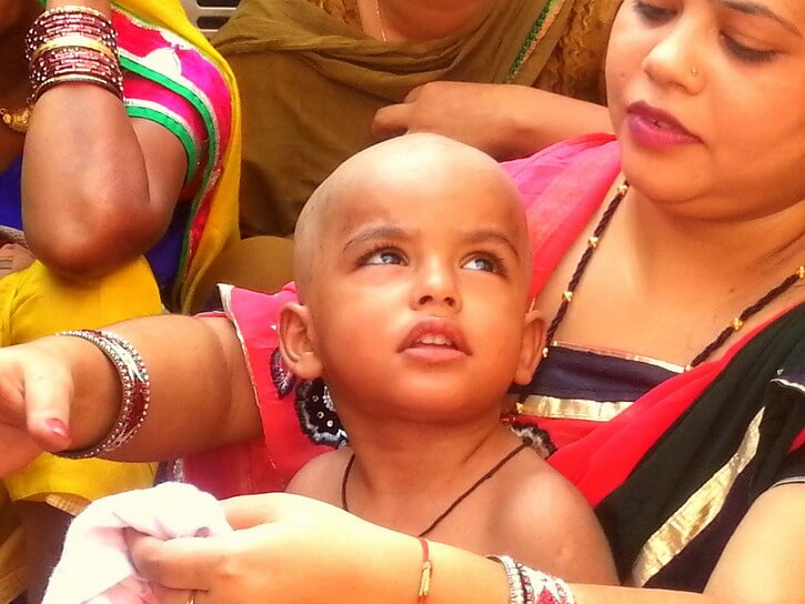 Un enfant dont les cheveux ont été tondus pour la première fois lors du Mundan