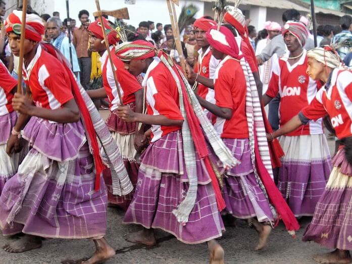 Dhurwa Tribe of Chhattisgarh State in India wearing white and red turbans and long white and purple dresses