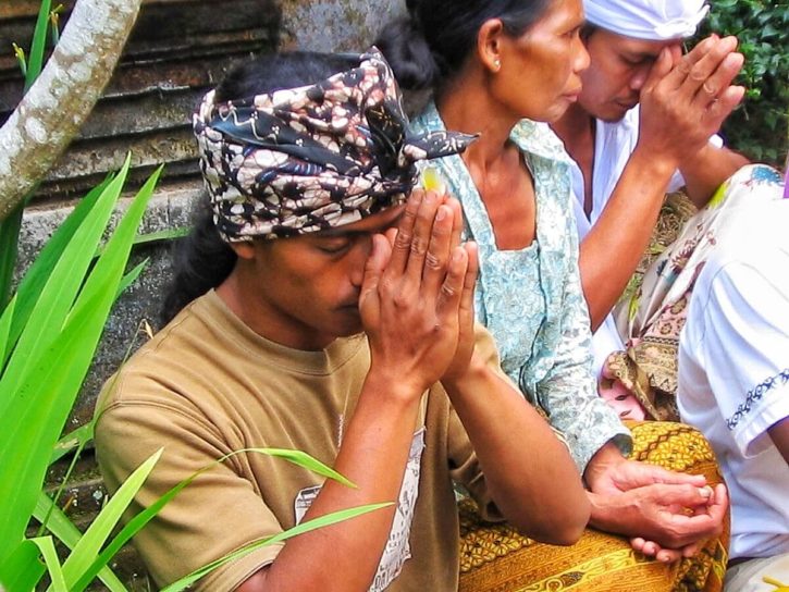 My Balinese friend Ketut praying in the temple before the tooth filling of his wife