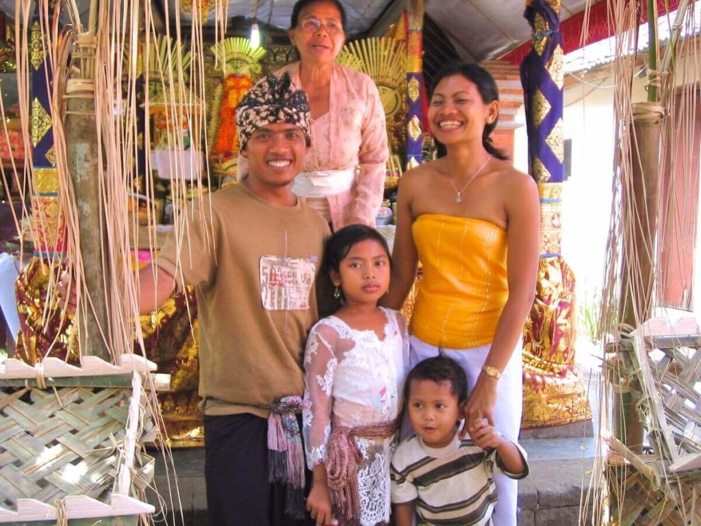 A Balinese couple wearing traditional attires posing with their two children