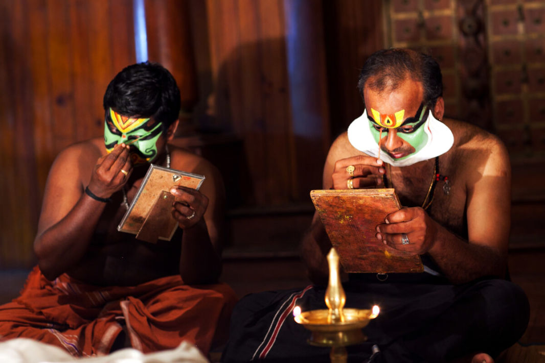 2 Kathakali actors doing make-up