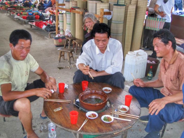 Three Chinese men around a table and hot pot