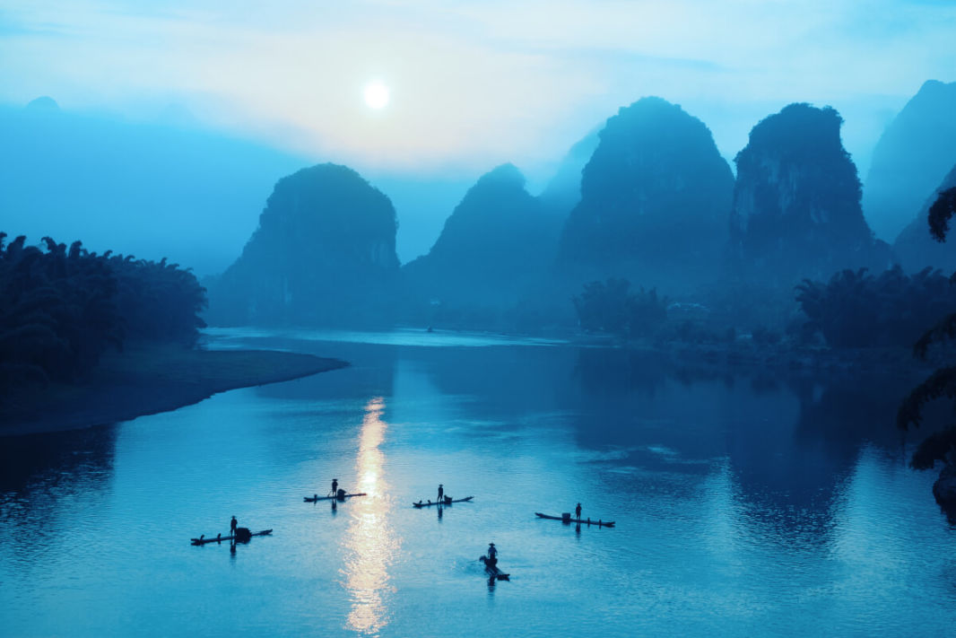 Karst peaks and boats on Li River by night