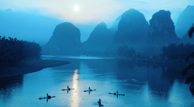 Karst peaks and boats on Li River by night