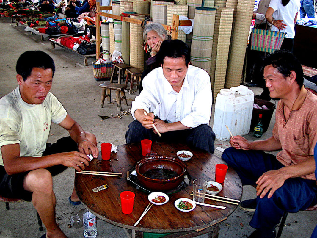 Men eating hot dog pot in Fuli market