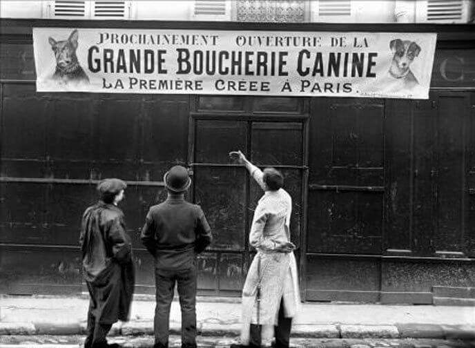 3 men in front of the first dog meat butchery in Paris