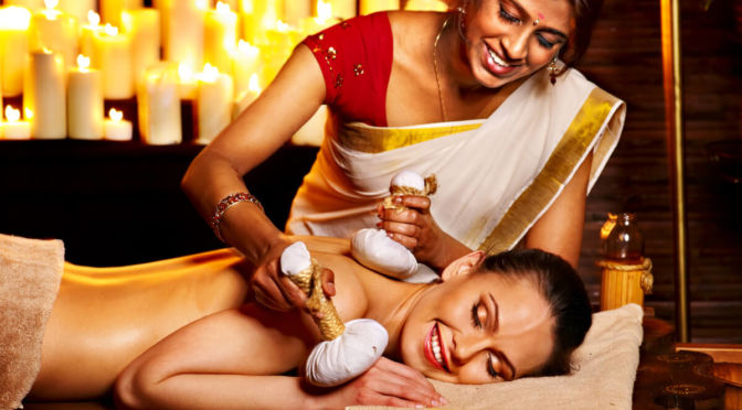 Indienne en saree faisant un massage ayurvédique avec des poches de riz