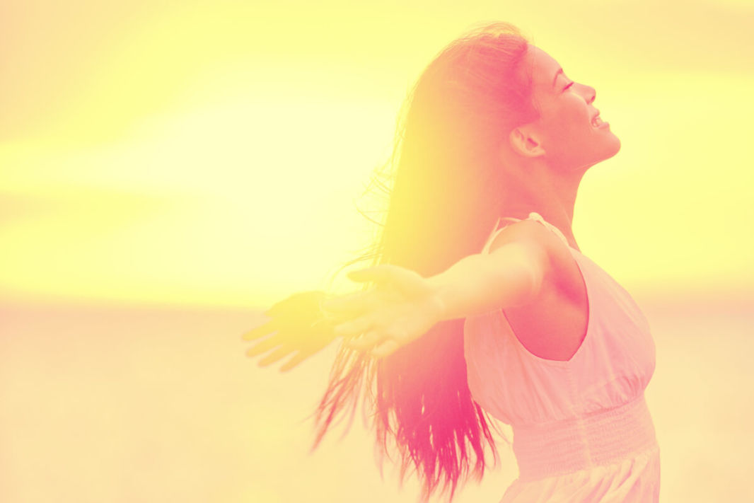 Woman enjoying the sun with wide open arms