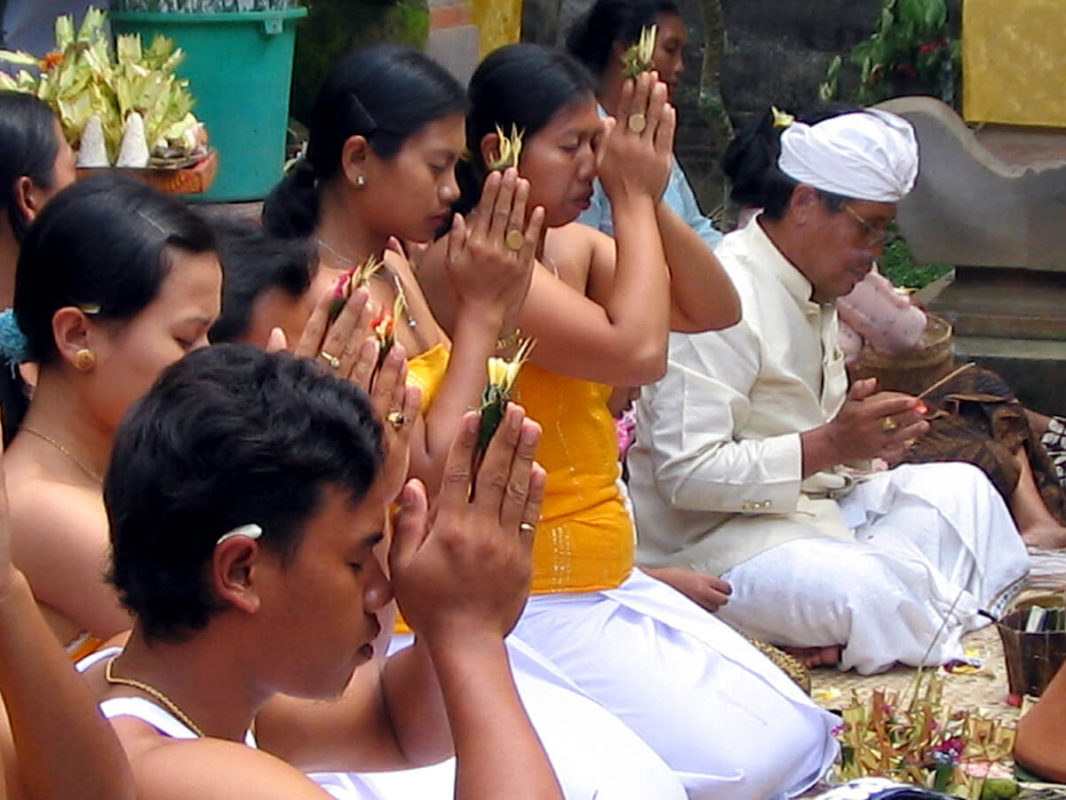 Balinaises et prêtres en train de prier dans un temple familial
