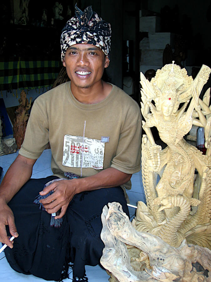 Balinese artist Ketut Sunarta with his Sarawasti sculpture made from crocodile wood