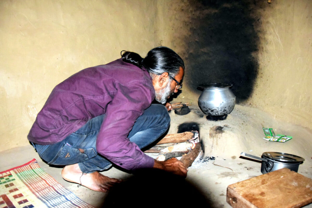 Shakeel cuisinant un poulet dans une cuisine tribale